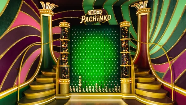Pachinko bonus round with the puck dropping through pegs toward the multiplier wall.